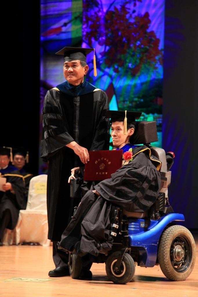 中山大學畢業生董庭吉（右）從小罹患脊髓型肌萎縮症，他以無比堅定的意志力，7日獲得資訊工程學系博士學位，還於前年通過高考，他的努力與成就獲得最多的喝采與掌聲。中央社記者王淑芬攝 103年6月7日圖片