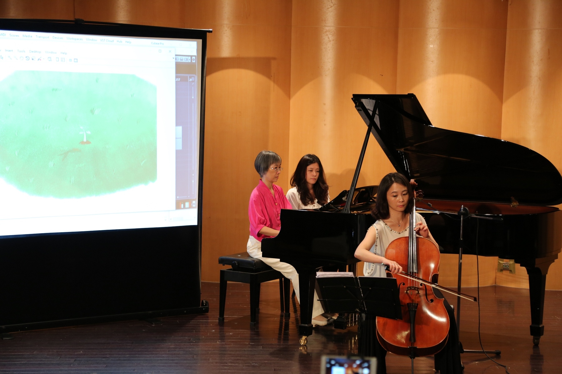 Prof. Kwang-I Ying and Assistant Prof. Jou-An Hou (right) playing the music and animations are triggered and shown on the screenImage
