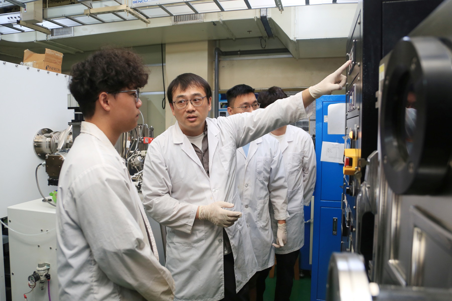 Associate Professor Hyeonseok Lee from the Department of Photonics at NSYSU guides graduate students in operating experimental equipment.Image