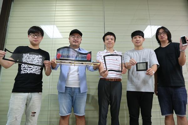The NSYSU Liquid Crystal team led by Distinguished Professor Tsung-Hsien Lin (middle) of the Department of Photonics develops a thin film that can be affixed to glass and by using a mobile application a person change the transparency of windows at any time!Image