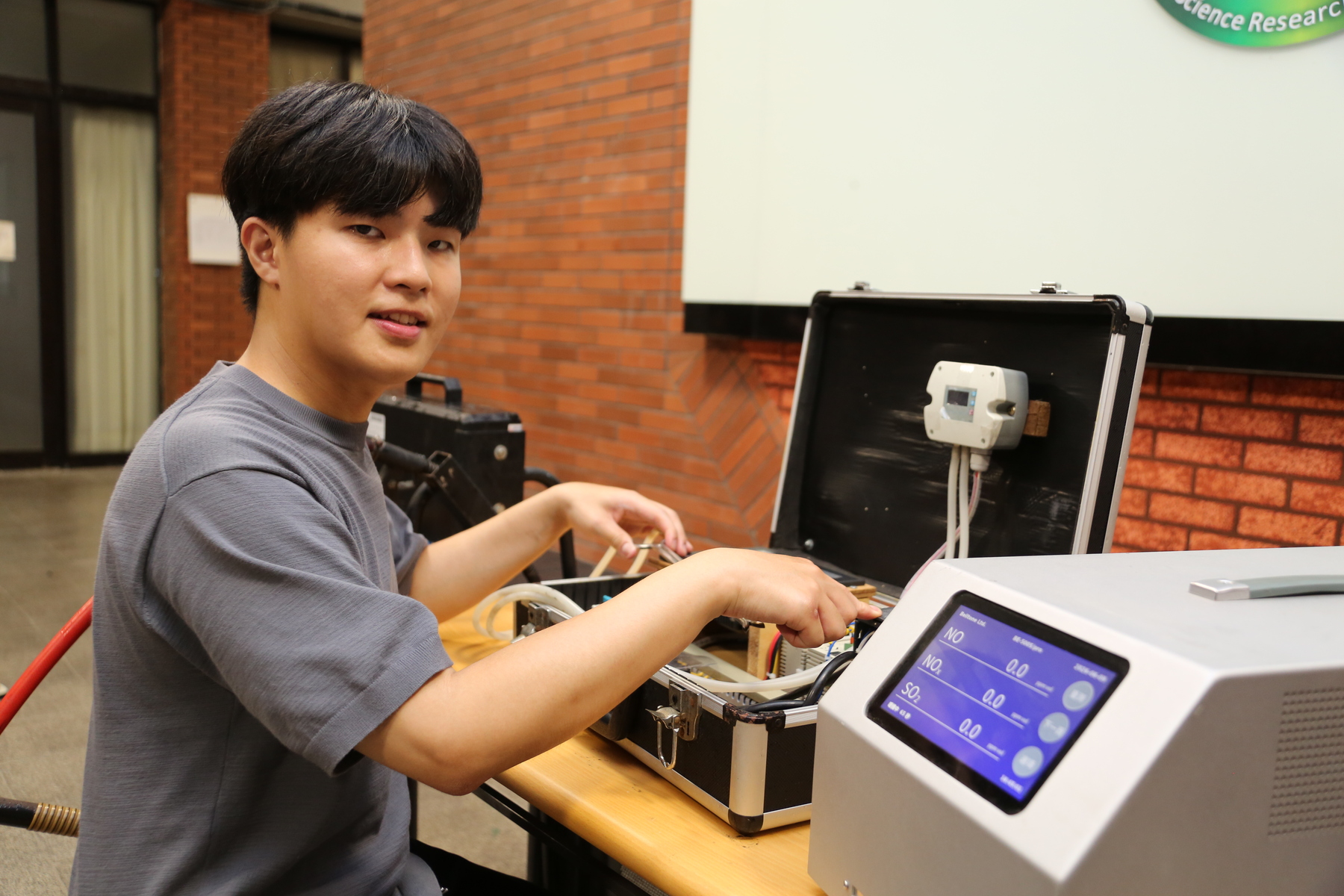 Po-Yen Chien, the study's first author and a doctoral student in the Institute of Environmental Engineering at NSYSU, introduces the equipment used for onboard sampling and real-time monitoring during vessel berthing operations.Image