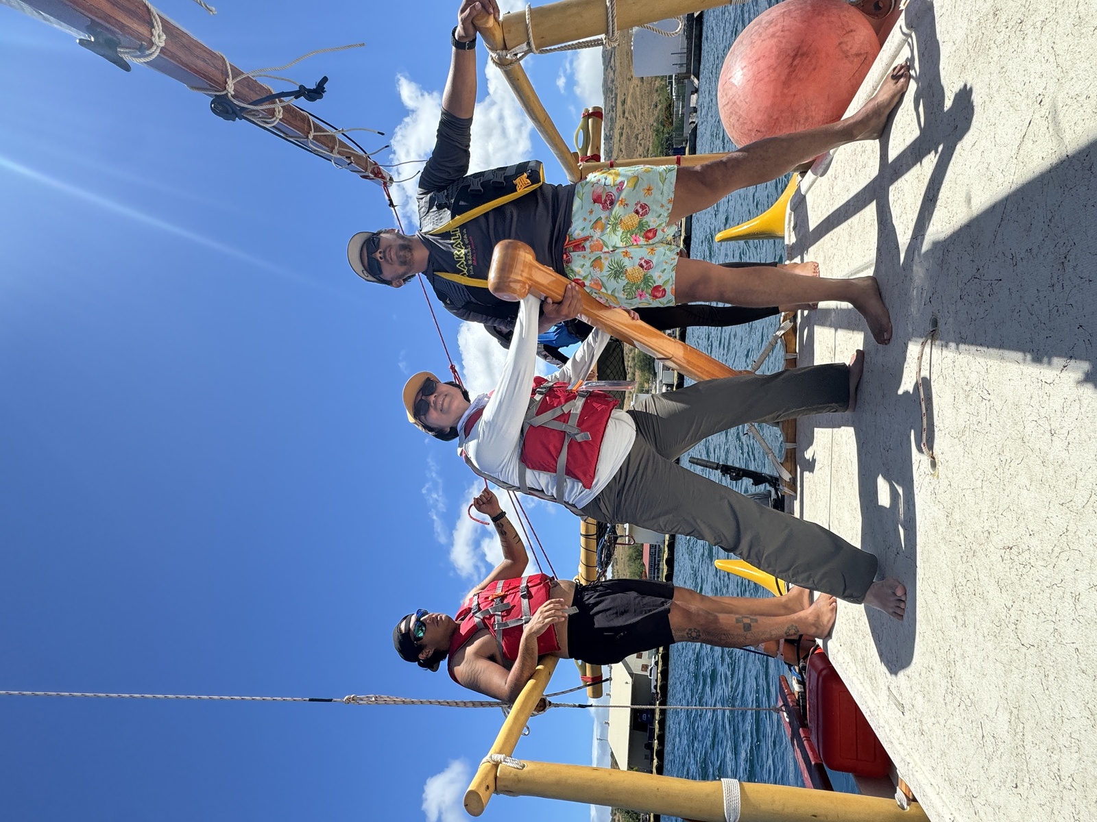 A student works with the hoe uli (steering paddle) aboard the double-hulled voyaging canoe.Image
