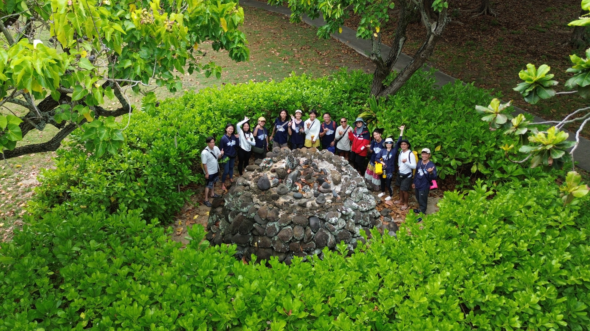 Participants at the voyaging ahu (altar), learning the modern history of Hawaiian voyaging.Image