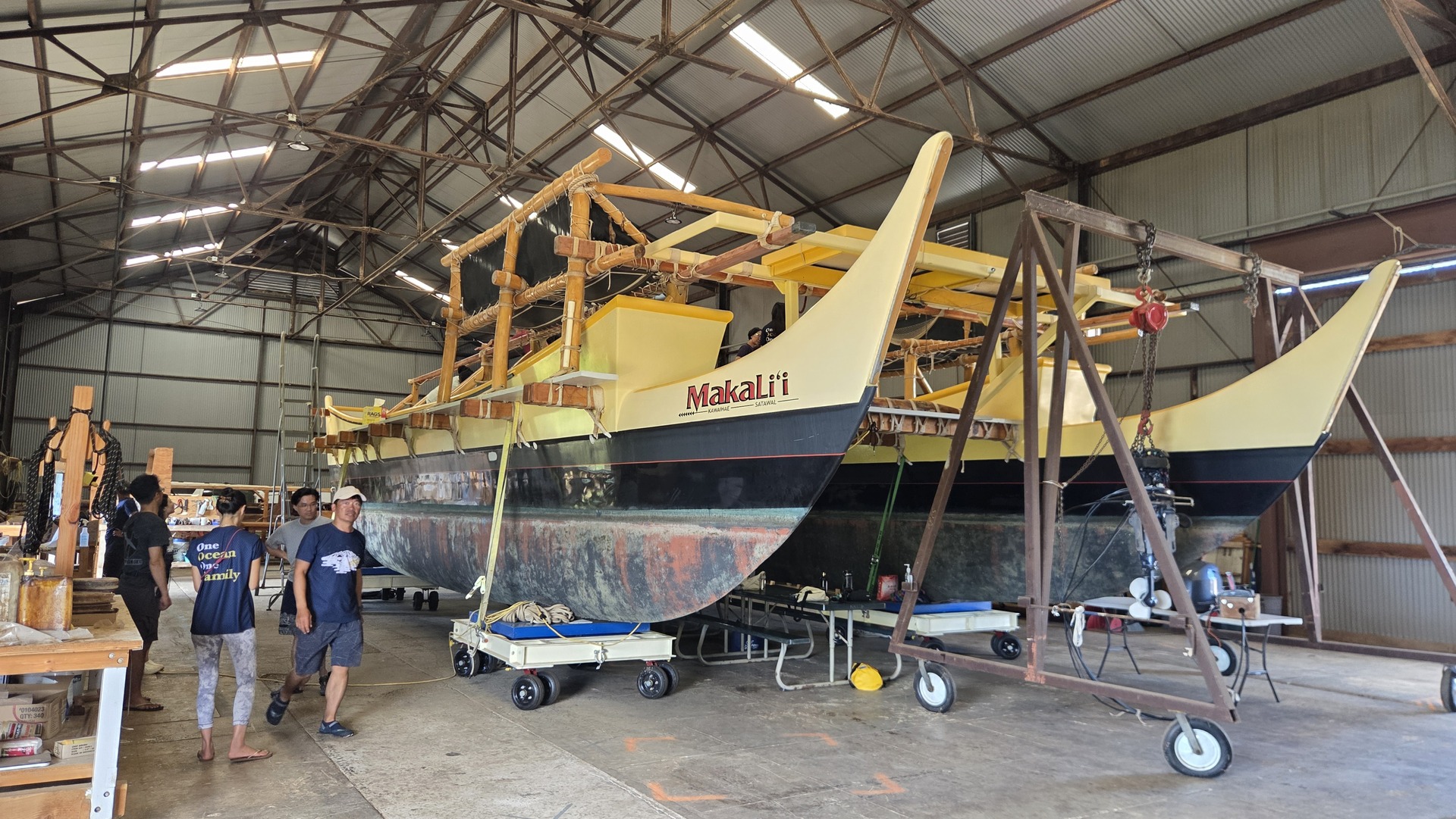 The double-hulled voyaging canoe Makaliʻi in dry dock inside the canoe house.Image