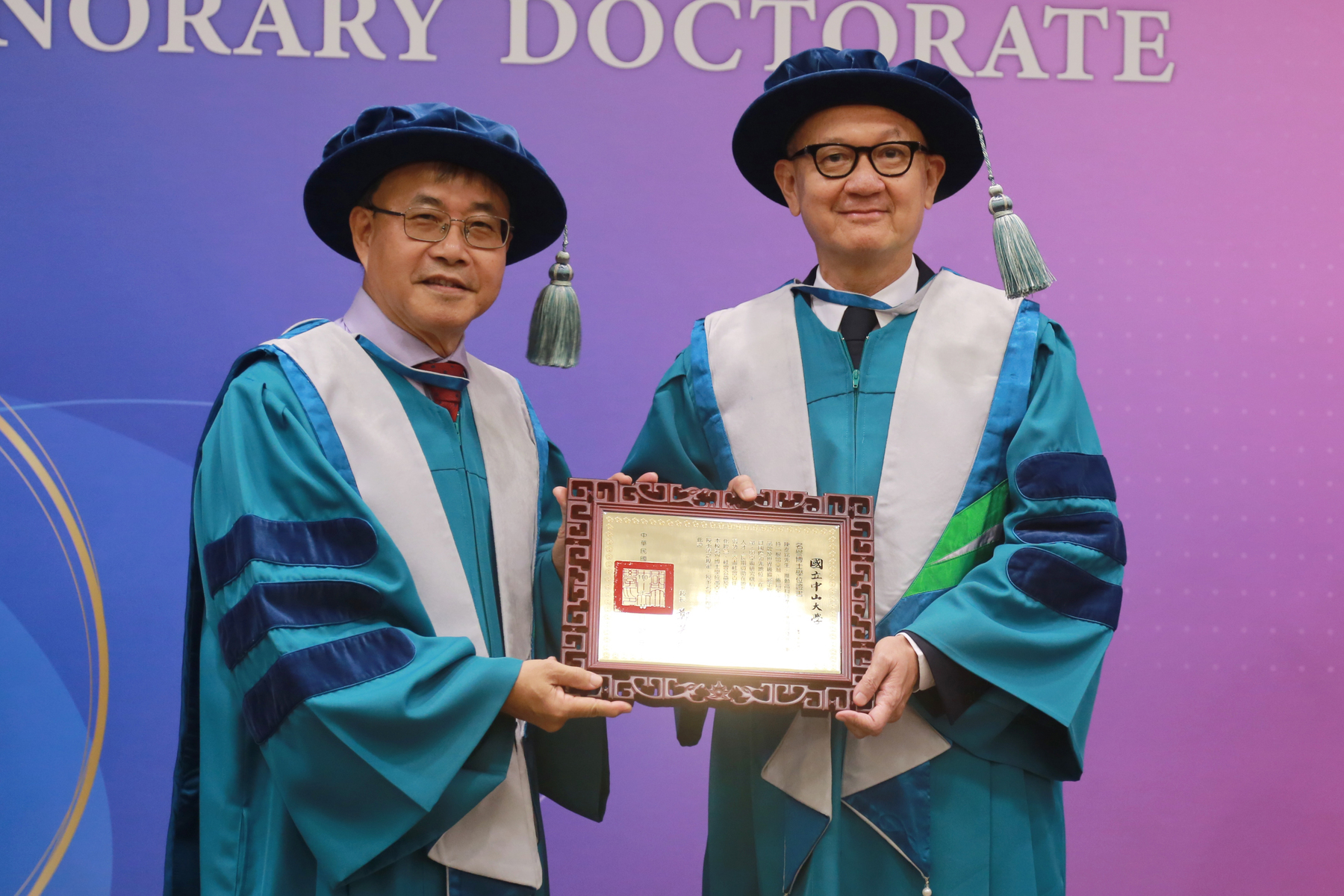 NSYSU President Ying-Yao Cheng (on the left) conferred the Honorary Doctorate in Management to the Chairman of Yageo Corporation Tie-Min Chen (on the right) as a recognition of his outstanding achievements in corporate management, and contributions to international art, education in Taiwan, and social welfare. Mayor of Kaohsiung Chen Chi-Mai participated in the ceremony.