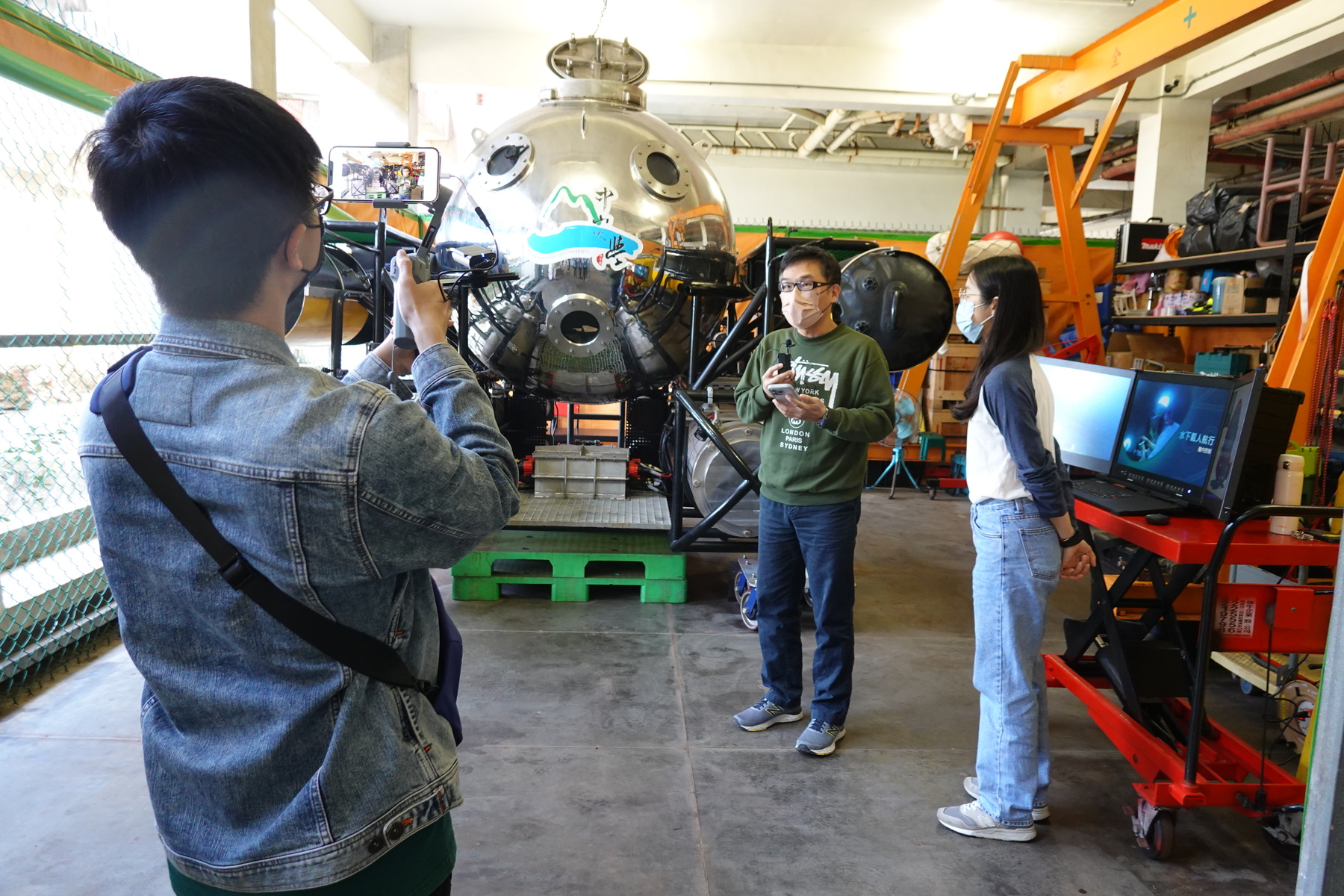 Associate Professor Yu-Cheng Chou of the Institute of Undersea Technology (second from the right) explained the process of NSYSU's R&D of the underwater manned vehicle.