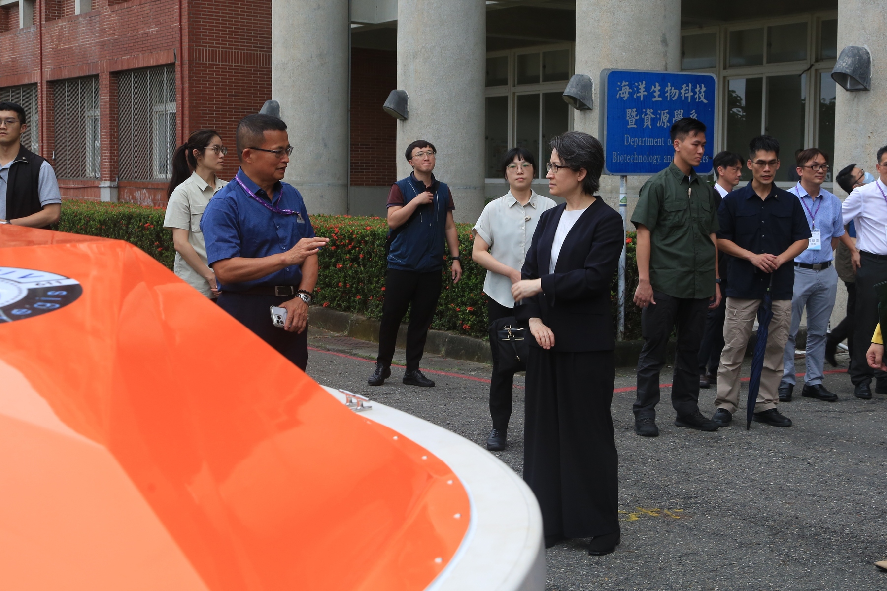 Professor Chua-Chin Wang from NSYSU's Department of Electrical Engineering (in blue) presents the smart unmanned vessel.Image