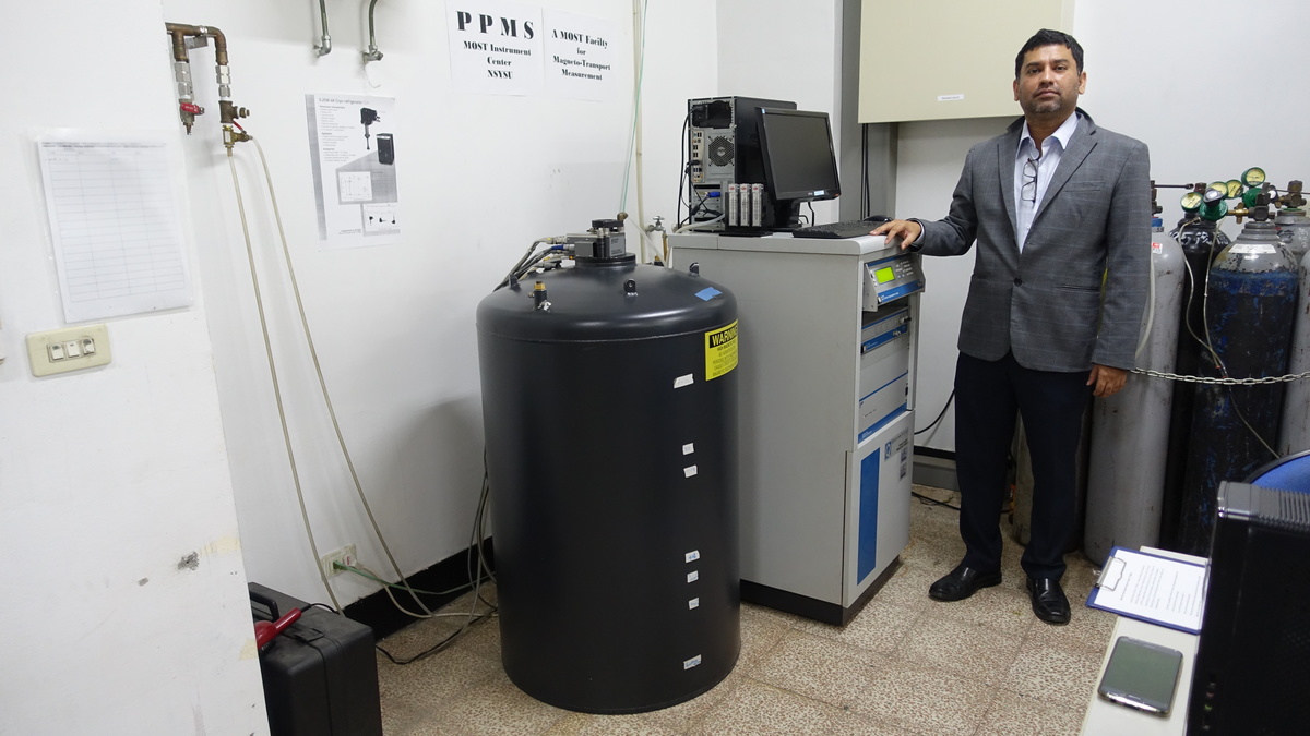 Assistant Professor Wadekar tests the properties of ferromagnetic semiconductors in the sample chamber filled with helium gas (black barrel) of the Physical Property Measurement System (PPMS).