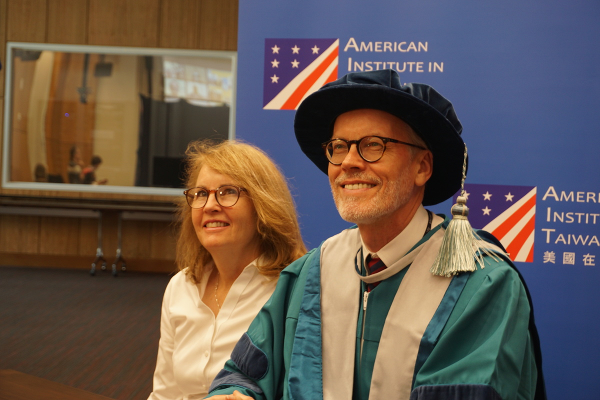 Director of American Institute in Taiwan Mr. William Brent Christensen (on the right) was conferred the Honorary Doctorate in Social Sciences from NSYSU. On the left is his wife, Brenda. (Photo provided by AIT)