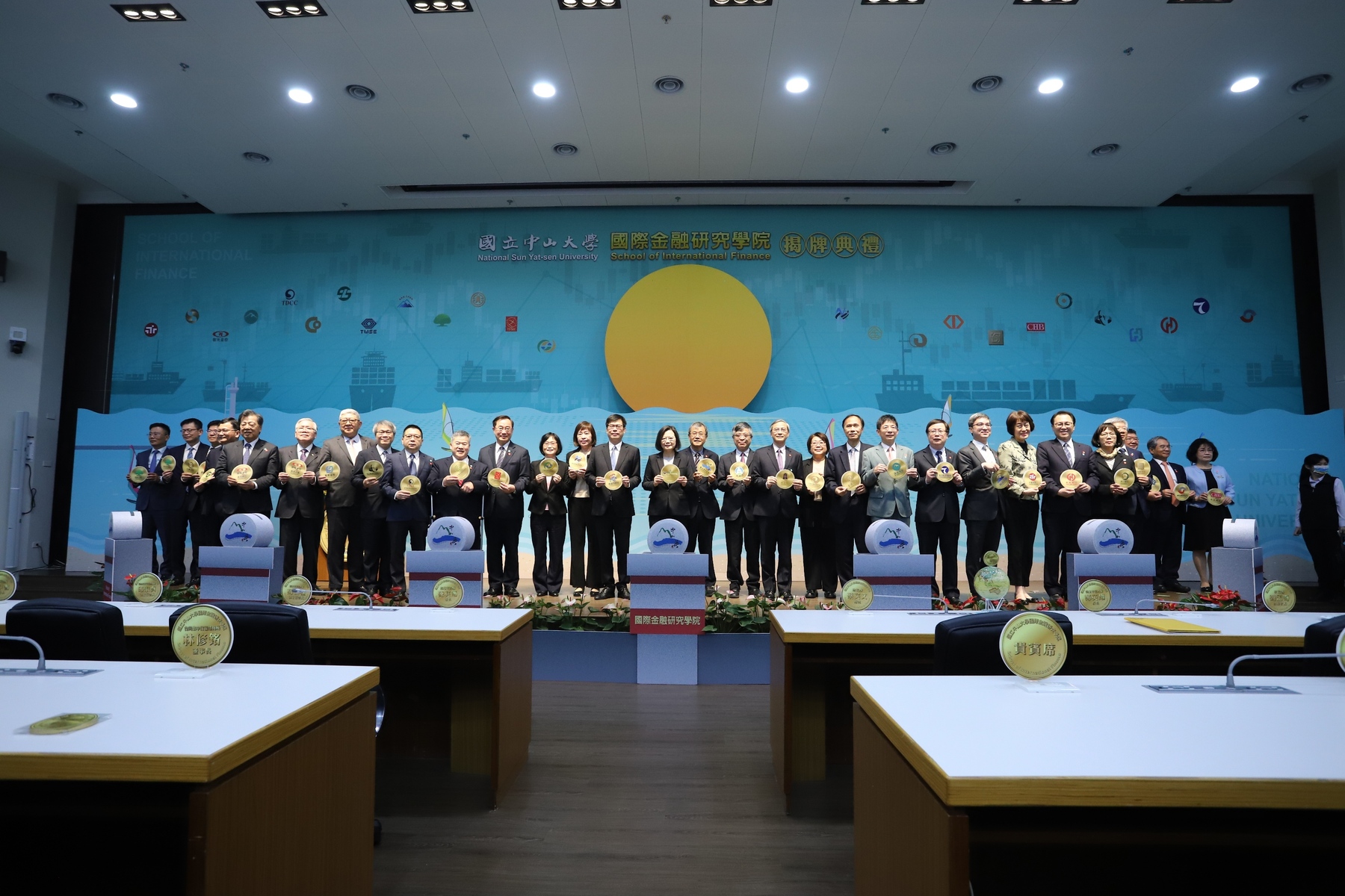 Inauguration ceremony of the School of International Finance. The stage design imitates the features of Sizihwan Bay including its beautiful sunsets, and incorporates gold coins as a decorative element, symbolizing the cooperation between industry, academia, and government in forming a team of finance professionals for Taiwan, reaching a new milestone.