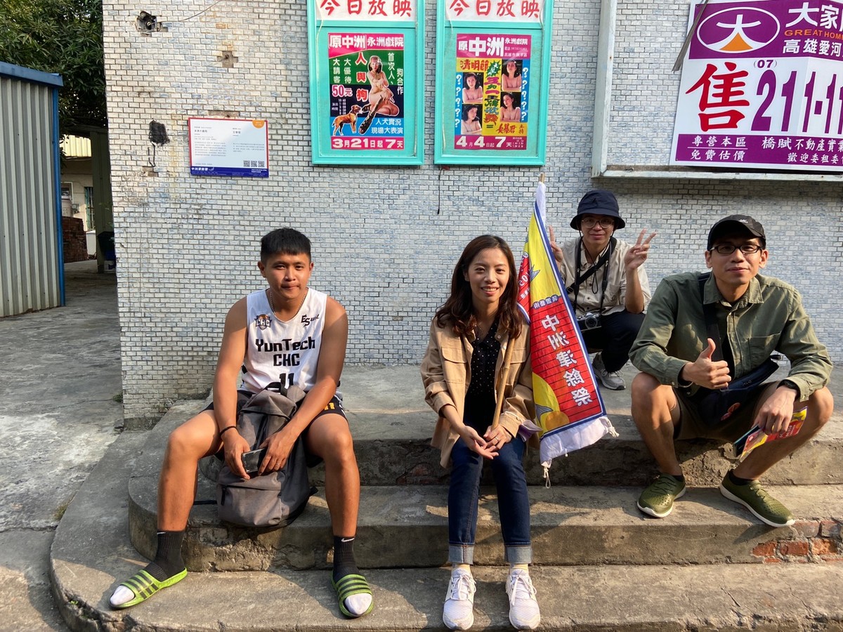 The curatorial team posing and visitors posing with the “Yongzhou Theatre” installation in the backgroundImage