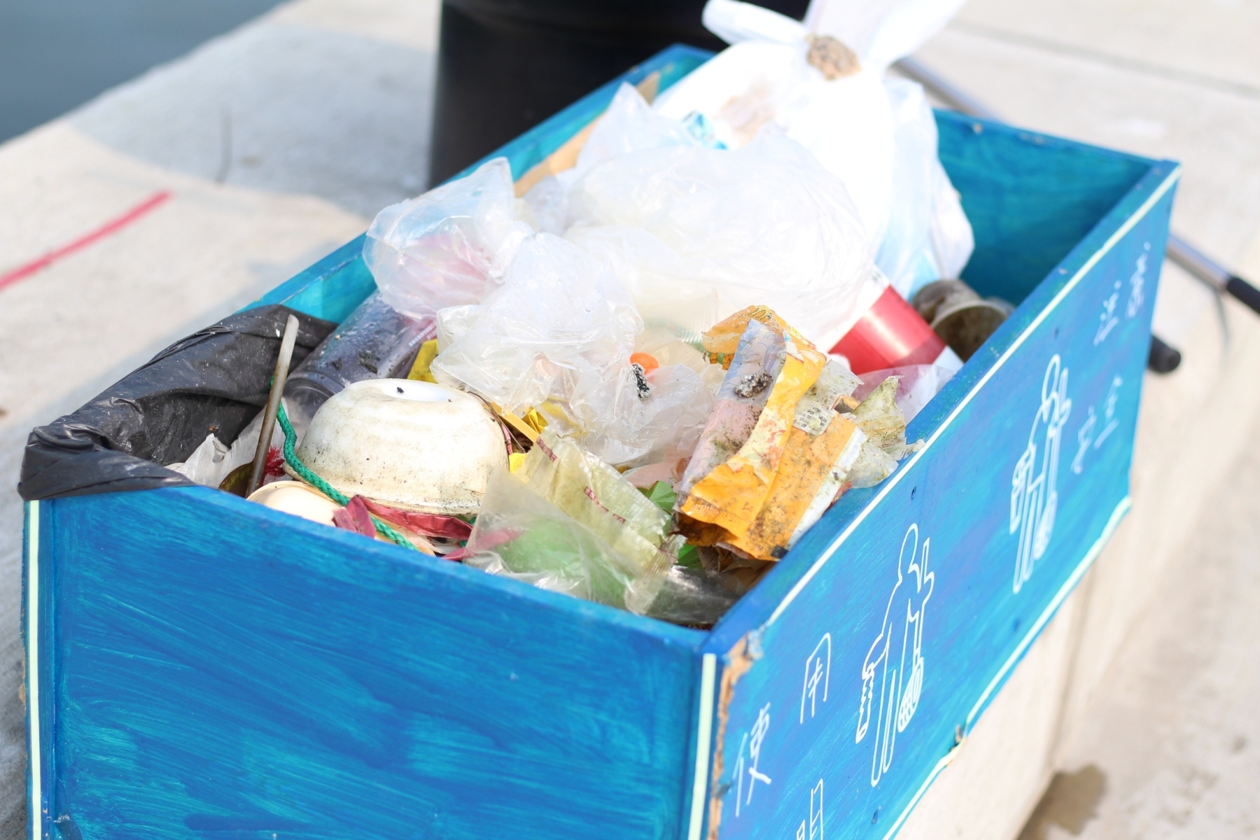 “Fishing for Goldfish” – ocean trash collected in a wooden boxImage