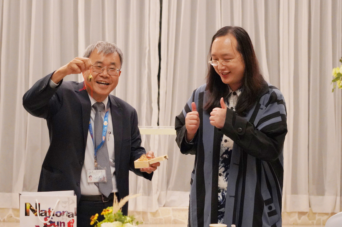 NSYSU invited Minister without Portfolio Audrey Tang (on the right) to discuss the development trends in social innovation in Taiwan. NSYSU President Ying-Yao Cheng (on the left) gave her a cowbell as a souvenir gift. / photo by Si Wan College