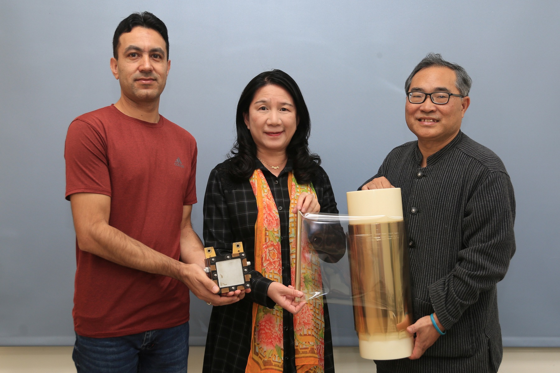 The team led by NSYSU professors Wen-Yao Huang (right) and Mei-Ying Chang (center) from the Department of Photonics developed the novel proton exchange membrane, with the research published in the International Journal of Hydrogen Energy. Co-author and PhD student Abid Hussain (left) from the Department of Photonics holds a single cell of the fuel cell incorporating the proton membrane.Image