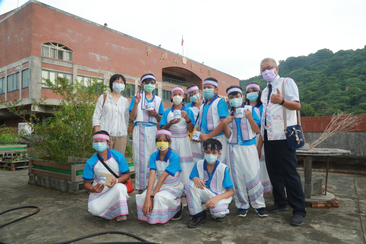 Associate Professor Hua-Mei Chiu of NSYSU Department of Sociology (first on the left in the second row) guided the pupils of Hualien Tongmen Elementary School to visit the solar panels and organic vegetable garden on the rooftop of the College of Social Sciences.