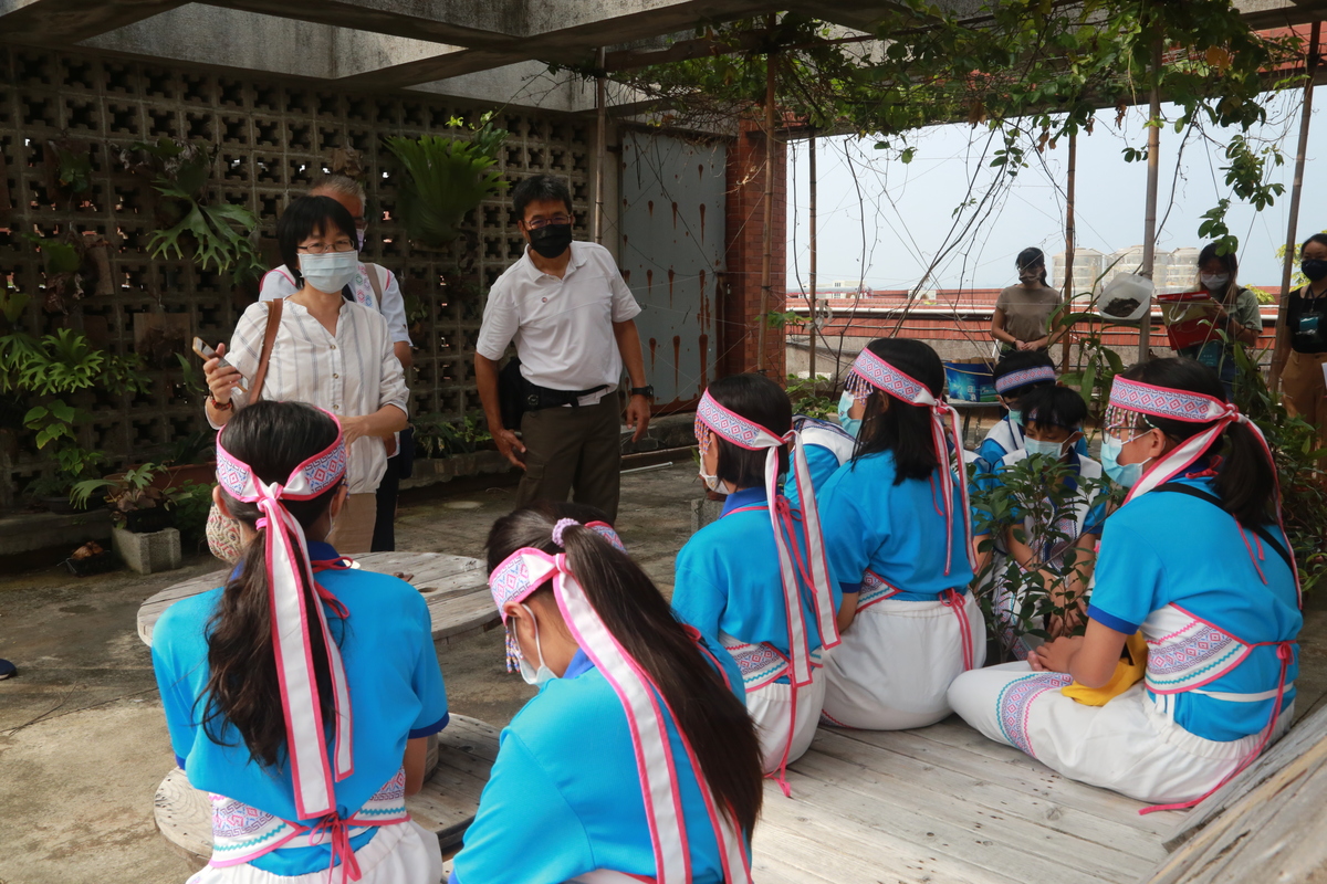 Associate Professor Hua-Mei Chiu of NSYSU Department of Sociology (first on the left in white shirt) led the pupils to learn about environmental sustainability by visiting the solar panels and organic vegetable garden on the rooftop of the College of Social Sciences.