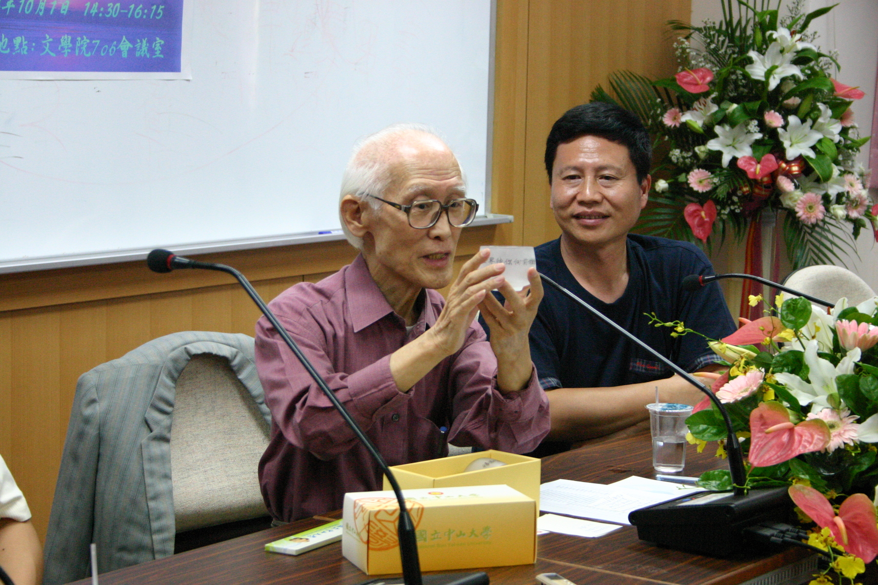 余光中拿出刻有余光中詩句的中山大學紀念磨沙玻璃杯，上頭寫著「這世界待你向前推動，像杯子旋轉在你掌中」，從左邊讀到右邊，恰好把這只杯子旋轉一圈，雖然說較少讀詩，但是生活中其實處處都詩意盎然圖片