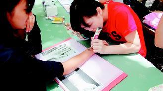 中山大學僑外週活動推出各式美食與文化體驗，印度彩繪的美麗圖案，吸引不少學生嘗試。 記者蔡容喬／攝影圖片