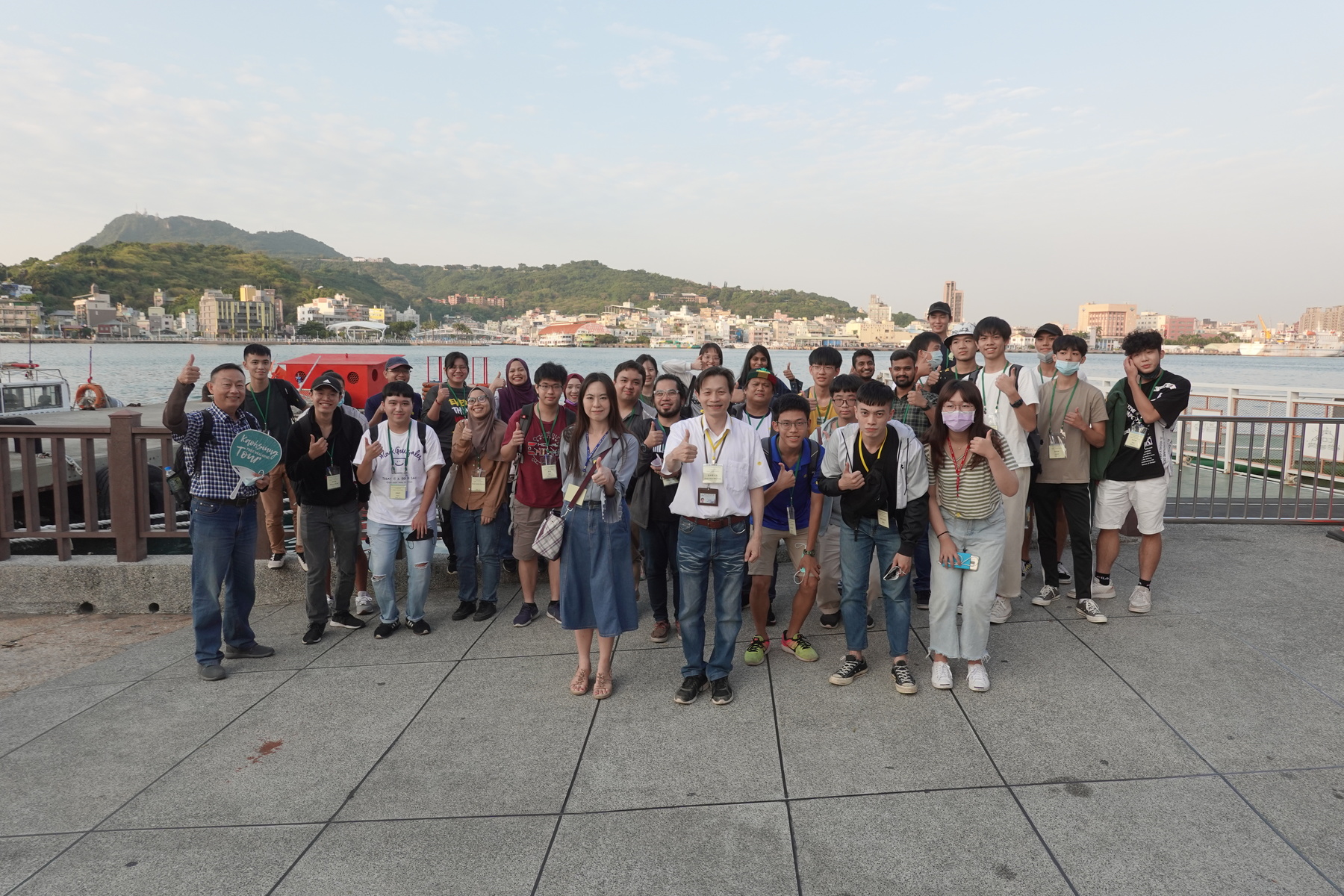 Students, guides, and NSYSU staff posing in front of the Port of Kaohsiung.Image