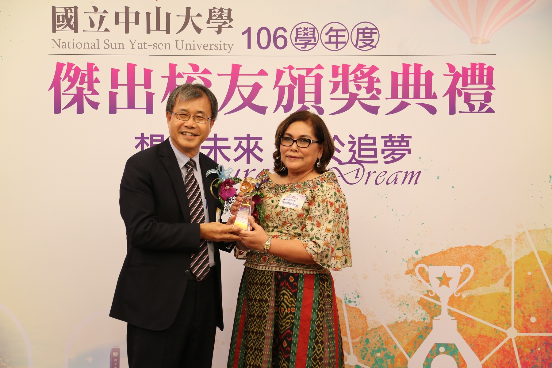 Dr. Gloria Jumamil-Mercado (right), receiving Distinguished Overseas Alumni Award from NSYSU President Ying-Yao ChengImage