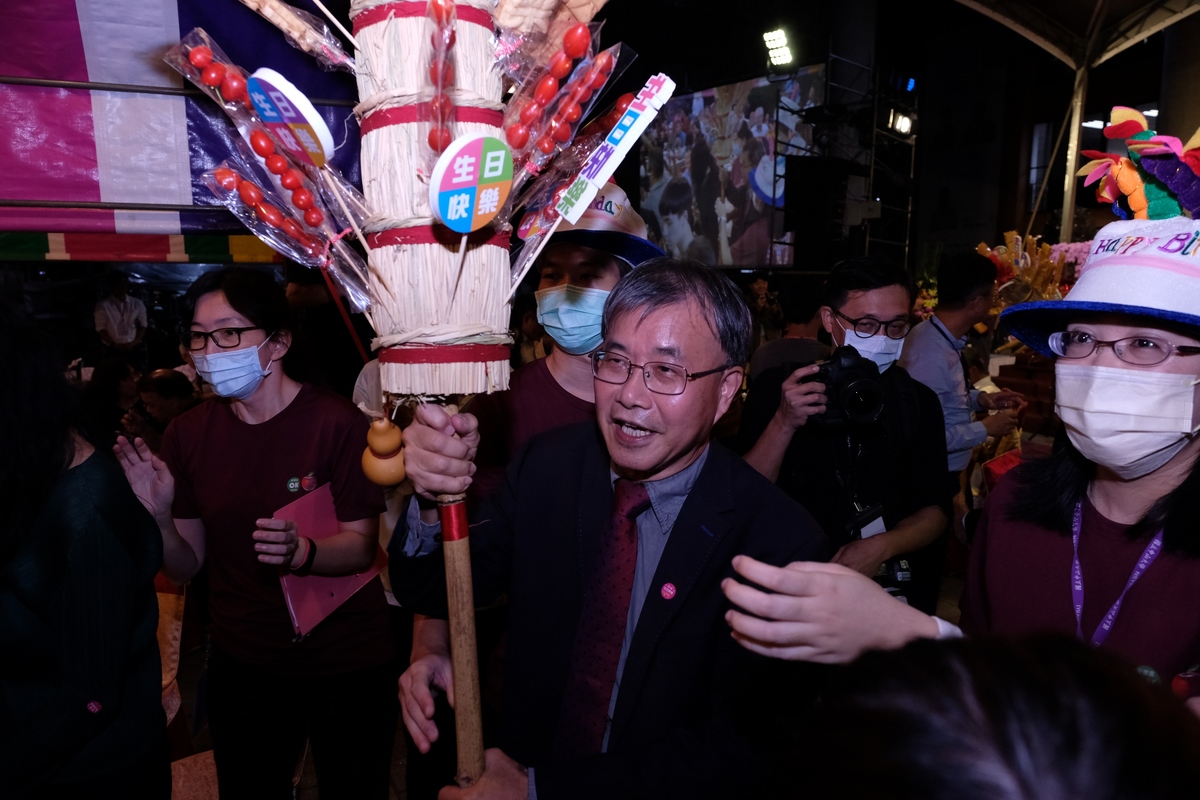 President Cheng handed in sugar coated fruit sticks and egg pancakes with birthday wishes to the alumni.