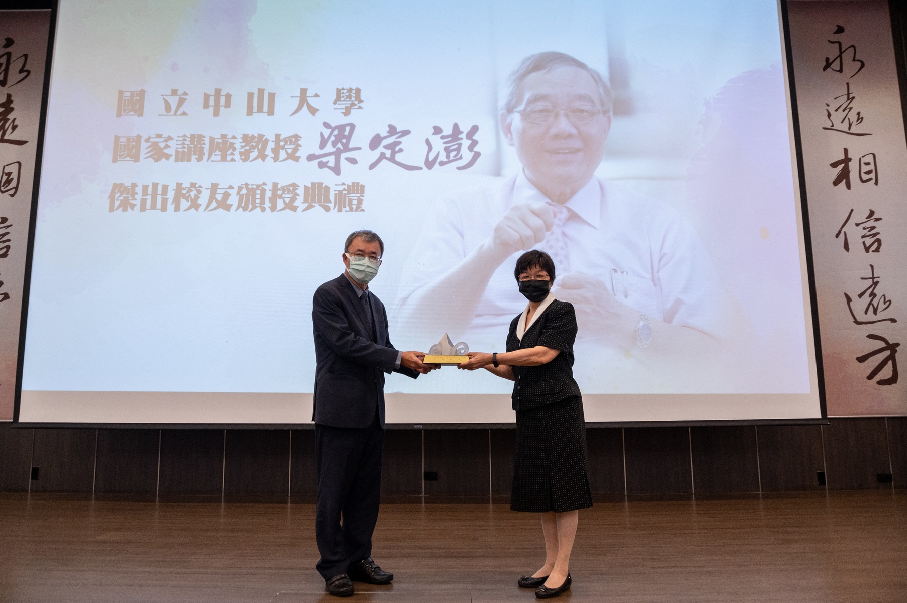 NSYSU President Ying-Yao Cheng (on the left) posthumously conferred the Outstanding Alumni Award to Professor Ting-Peng Liang during the memorial service. Professor Liang’s widow Chen-Li Wang (on the right) received the Award in the name of her late husband.
